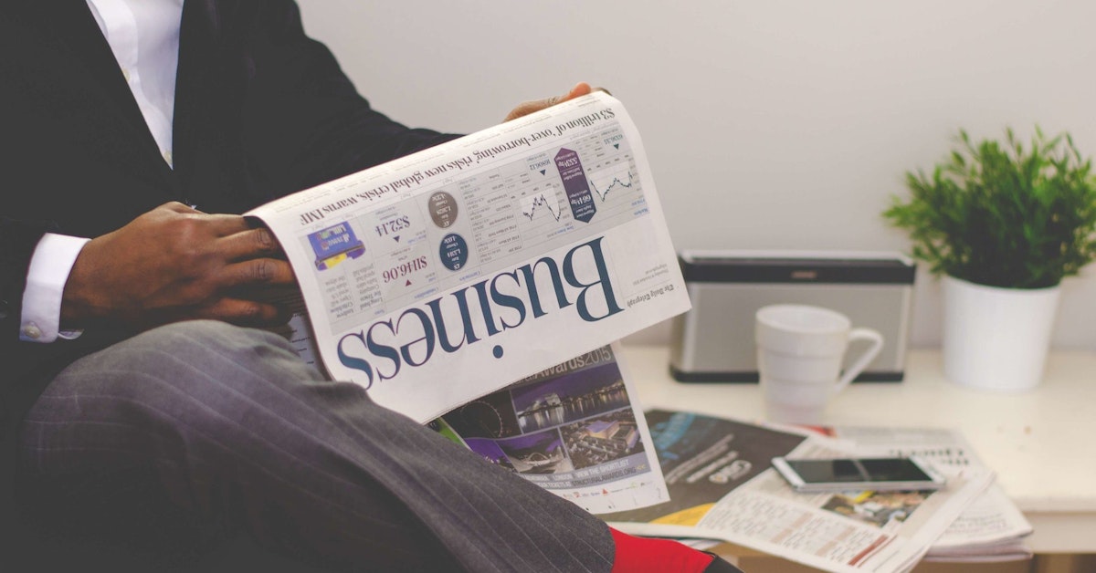 man reading a business newspaper man reading a business newspaper