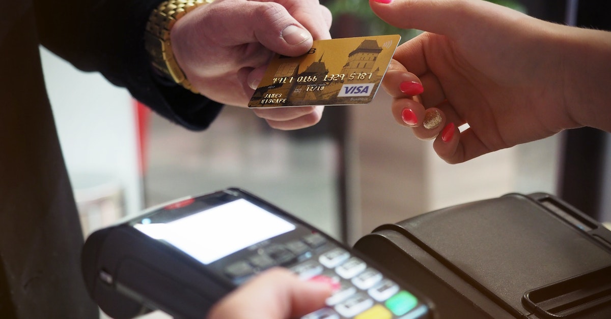 person paying with a gold card on a payment terminal person paying with a gold card on a payment terminal